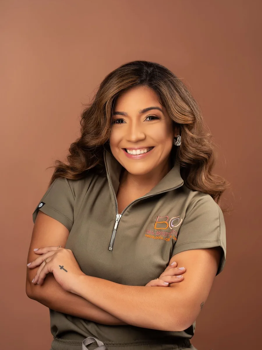 La Dra. Brigitte Castillo, sonriente, con su uniforme verde oliva con el logo BC bordado